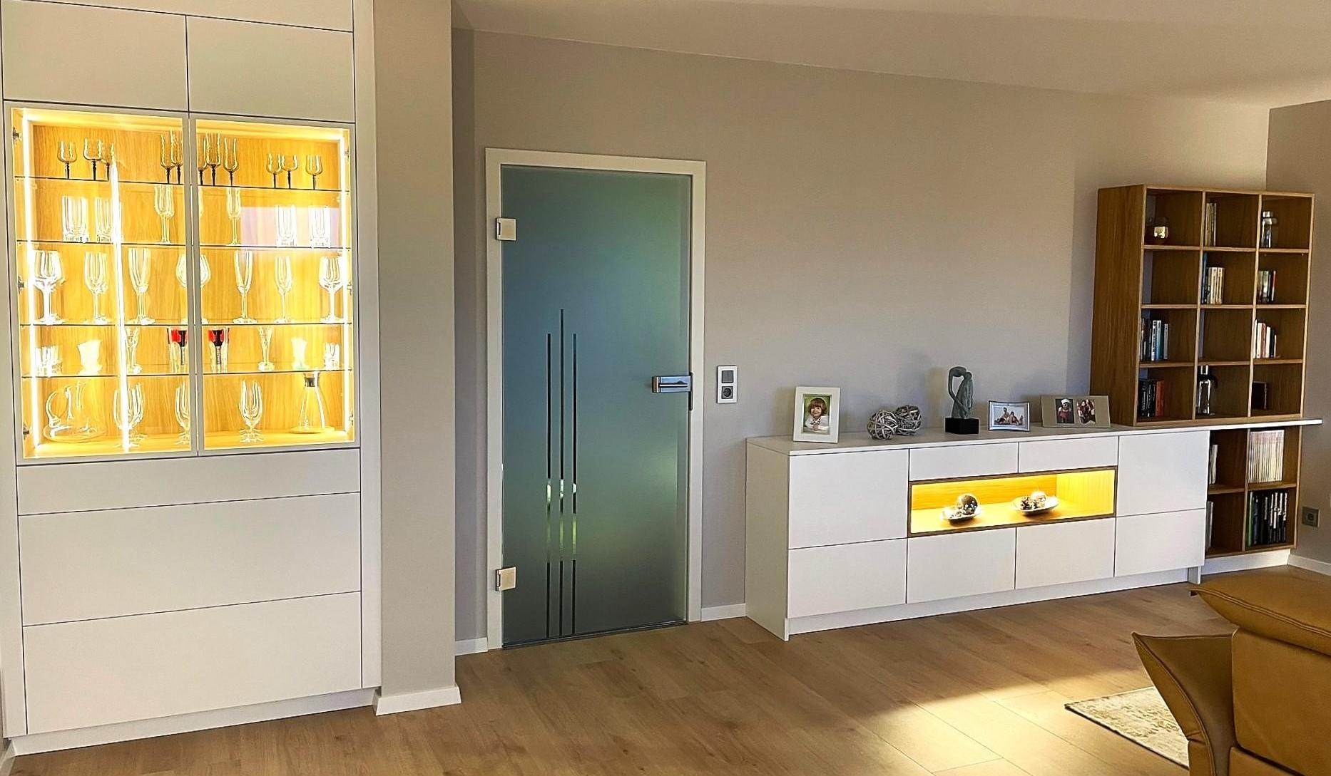 Wohnzimmer mit Vitrine, Sideboard und Bücherregal.