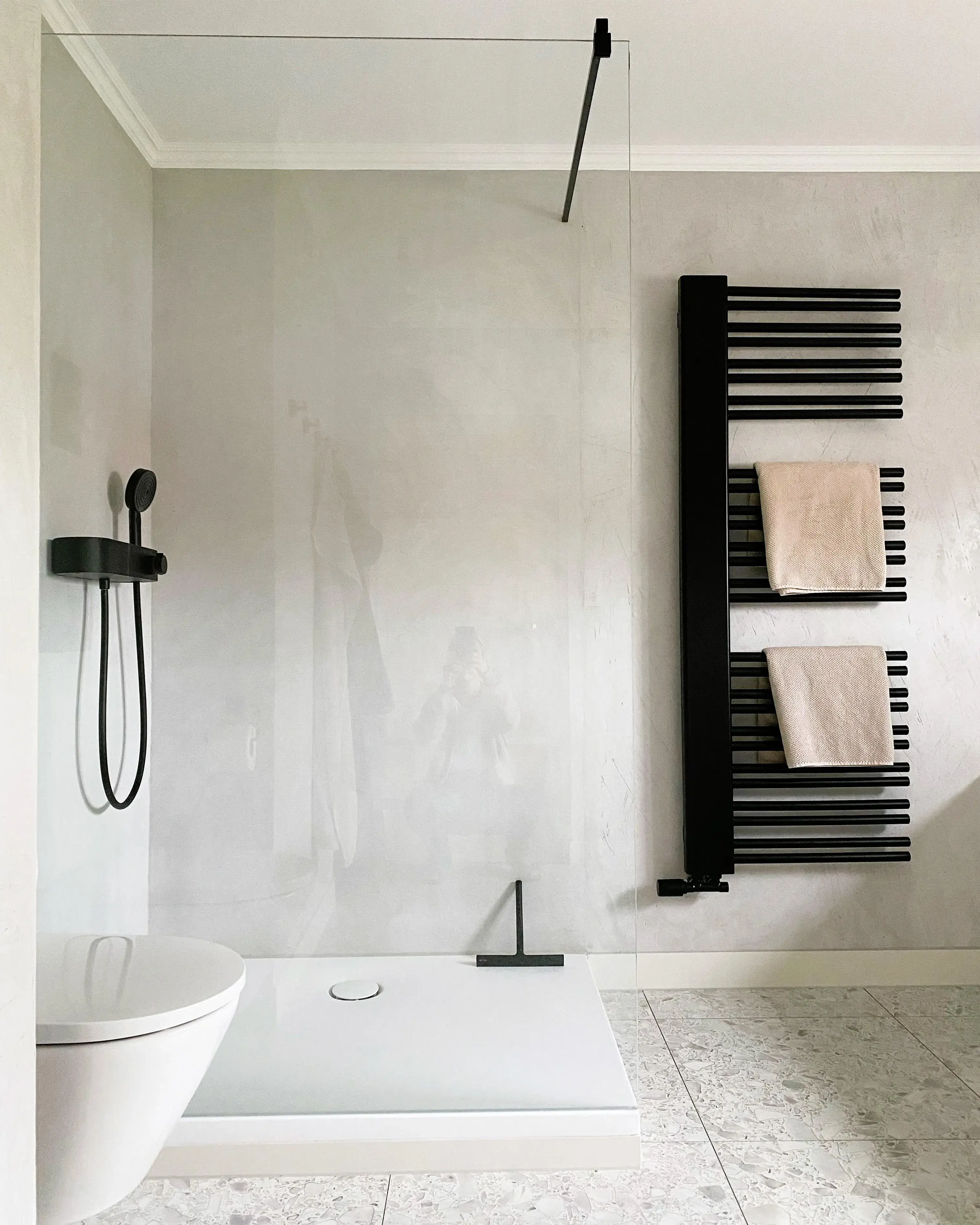 Große gläserne Dusche mit Handtuchhalter daneben