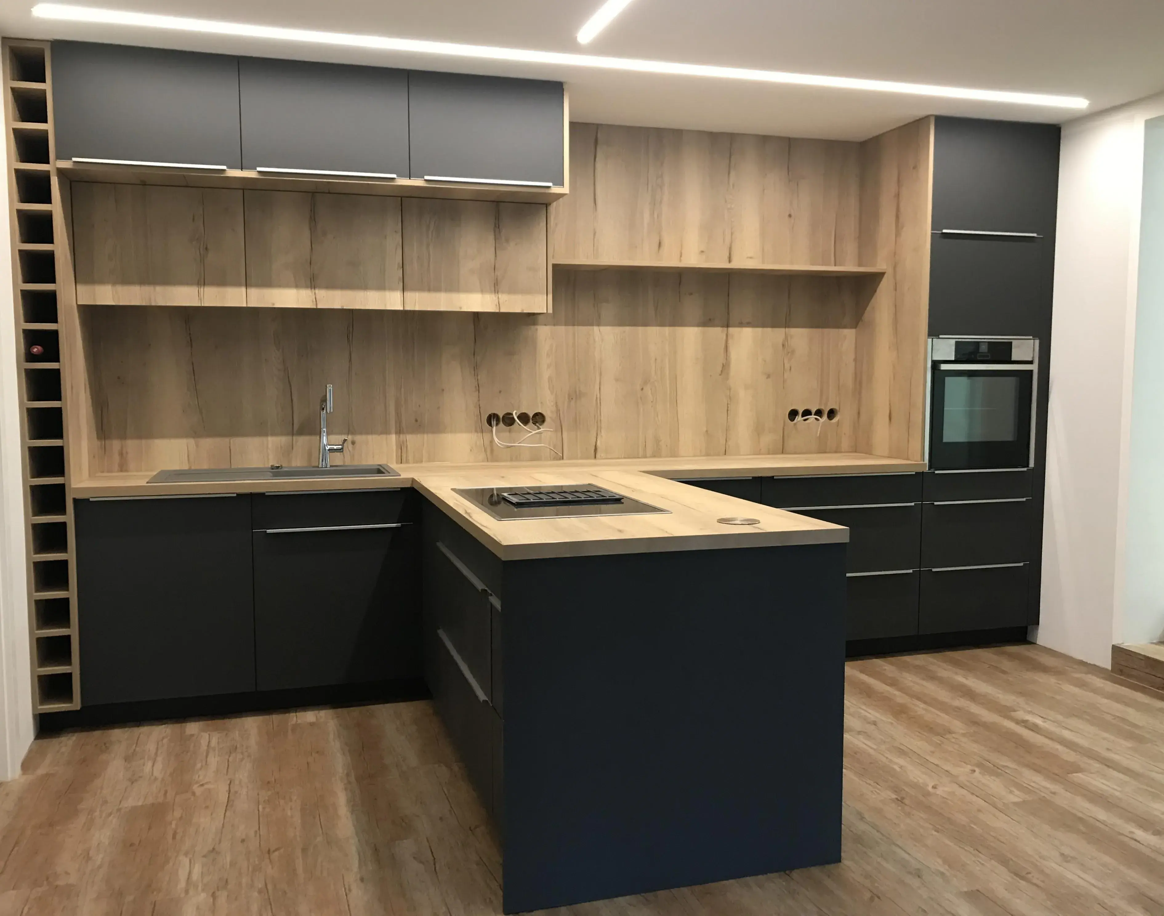 Moderne Einbauküche in Holz und Dunkelgrau mit Kochinsel und Einbauofen