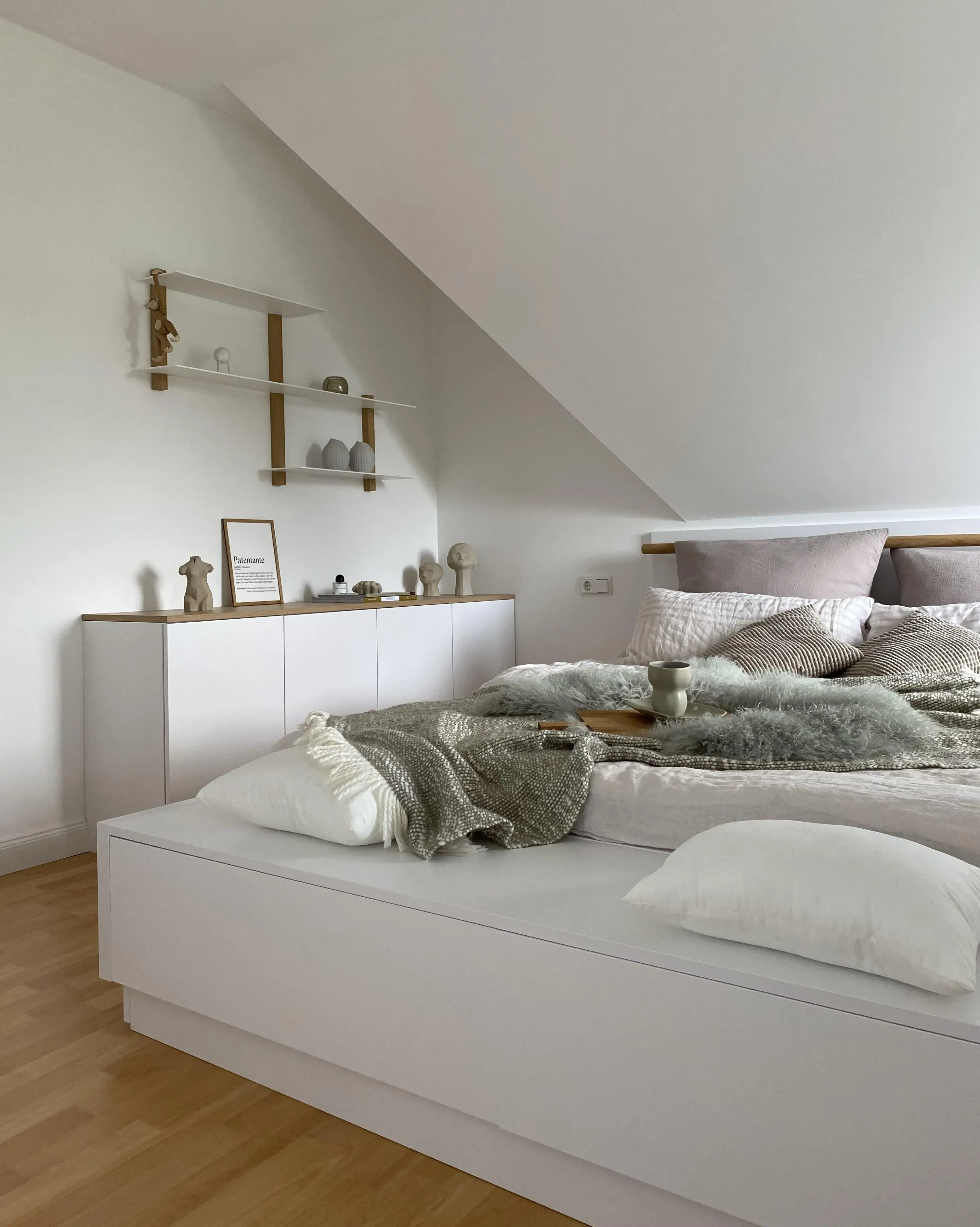 Gemütliches Schlafzimmer mit Sideboard und Regalen, schön dekoriert.