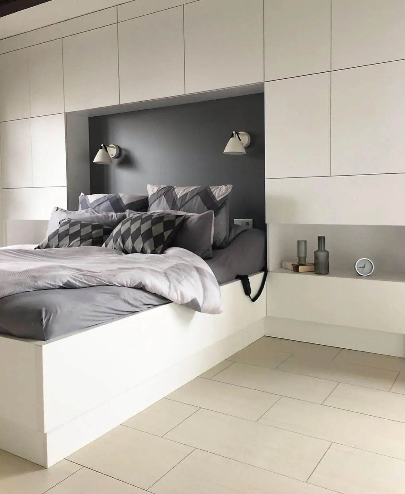 Bett mit Schrankwand dahinter, die viel Stauraum bietet. 